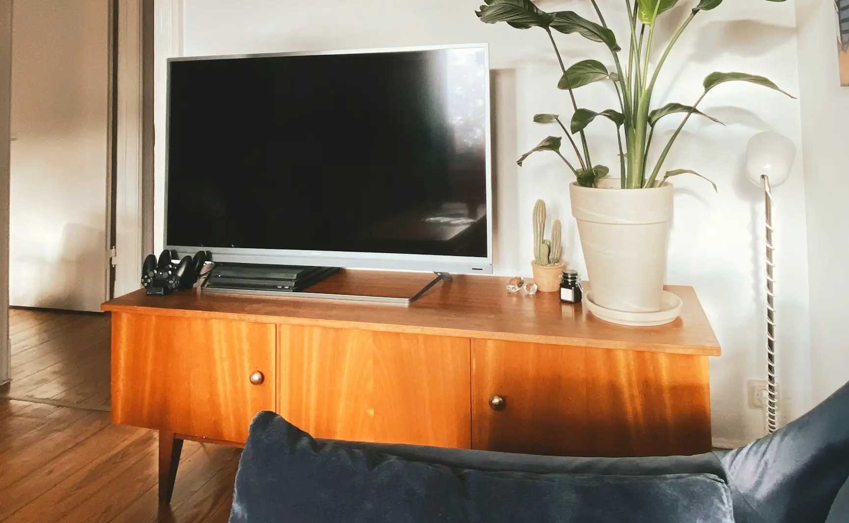 a flat screen tv sitting on top of a wooden dresser